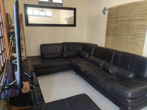 a black leather couch in a living room at Corazón Abierto in Chicxulub