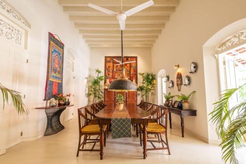 a dining room with a wooden table and chairs at The Sun House in Galle