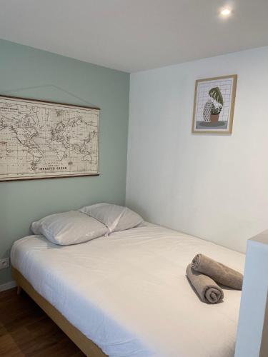 1 cama en una habitación con un mapa en la pared en Le Farconnet, en Tournon-sur-Rhône
