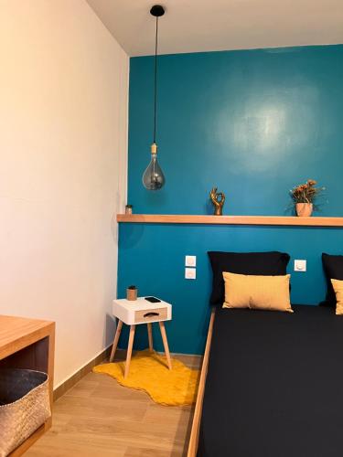 a room with a bed and a blue wall at DUPLEX 101 in Dzaoudzi