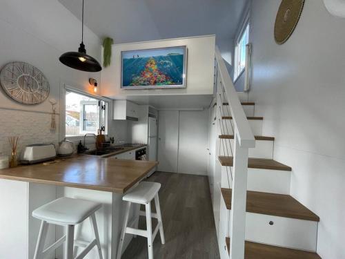 a tiny house with a kitchen and a staircase at Little River at Sussex Inlet in Sussex inlet