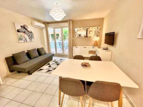 un salon avec une table et un canapé dans l'établissement Appartement Canne 1 chambre - 52C, à Cannes