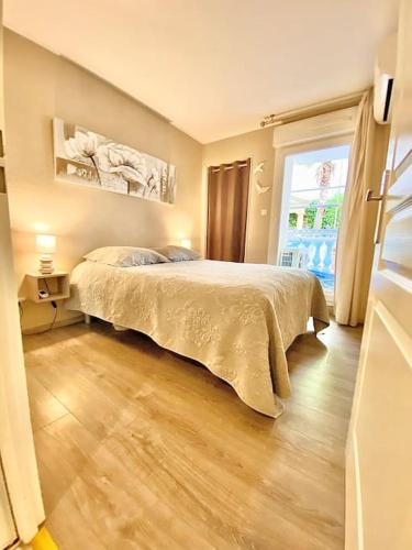 une chambre avec un lit et une grande fenêtre dans l'établissement Appartement Canne 1 chambre - 52C, à Cannes