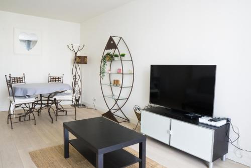 TV a/nebo společenská místnost v ubytování Élégant apt avec vue Tour Eiffel & parking privé