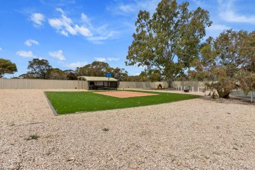 a baseball park with a baseball field and a tree at Costello Hotels - Moonta Bay Cabins in Port Moonta