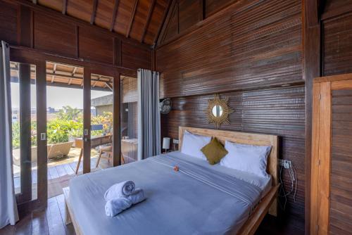 a bedroom with a bed with towels on it at Canggu Spirit Guest House in Canggu