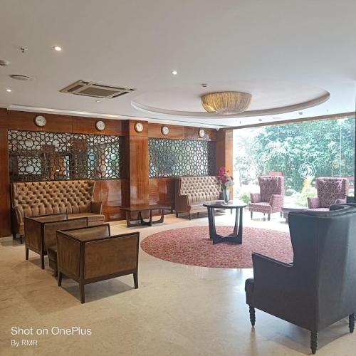 a lobby with chairs and tables in a building at ASTRA HOTELS & SUITES WHITEFIELD NEAR TO NALLURAHALLI METRO STATION and KTPO in Bangalore