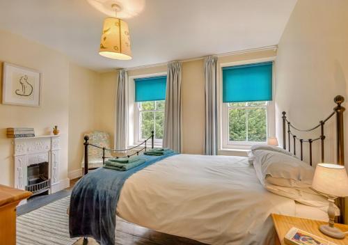 een slaapkamer met een groot bed en 2 ramen bij 3 St Mary's Villas in Hay-on-Wye