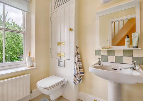 een badkamer met een toilet, een wastafel en een raam bij 3 St Mary's Villas in Hay-on-Wye