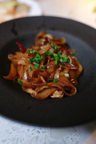 a black plate of food with sauce and green onions at The Nook Hotel Hangzhou - A design hotel, 20 mins to West Lake and Lingyin Temple in Hangzhou