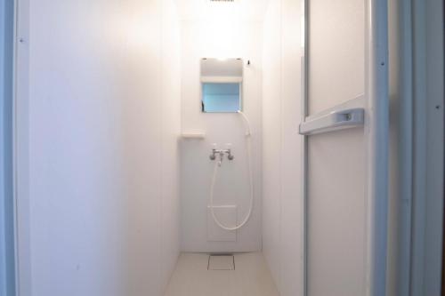 - une salle de bains blanche pourvue d'une douche dans l'établissement Ko-Fu-Sou, à Tokyo
