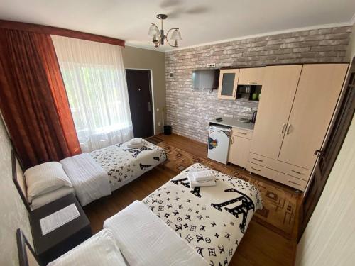 uma sala de estar com 2 camas e uma cozinha em Арт-отель ololoFamily em Chon-Sary-Oy