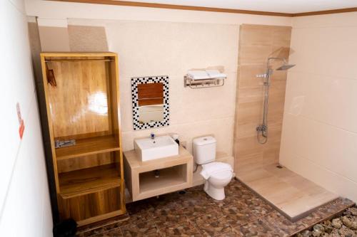 a bathroom with a toilet and a sink and a shower at Shava Beach Resort in Gorontalo