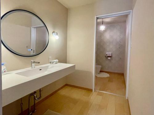 a bathroom with a sink and a mirror and a toilet at 与論島〜2023年10月25日にリニューアル〜ヴィラ島福家一軒家貸別荘 in Yoron