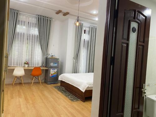 a bedroom with a bed and a desk and a chair at Lu Peaceful Homestay in Da Nang