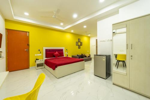 um quarto com uma cama vermelha e uma parede amarela em Seethala Bed & Breakfast em Pondicherry