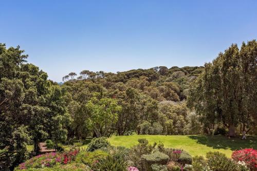 a garden with trees and grass and flowers at Caves House Hotel & Apartments Yallingup in Yallingup
