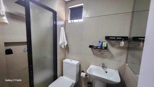 La salle de bains est pourvue d'une douche, de toilettes et d'un lavabo. dans l'établissement Veranda Condo, 
