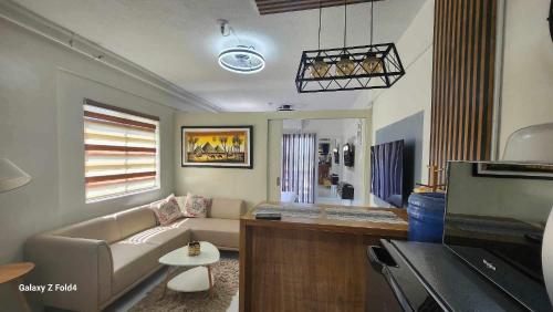 - un salon avec un canapé et une table dans l'établissement Veranda Condo, 