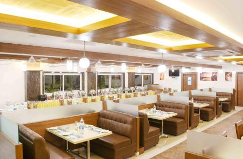 un restaurante con sofás y mesas en una habitación en Holiday Residency Coimbatore en Coimbatore