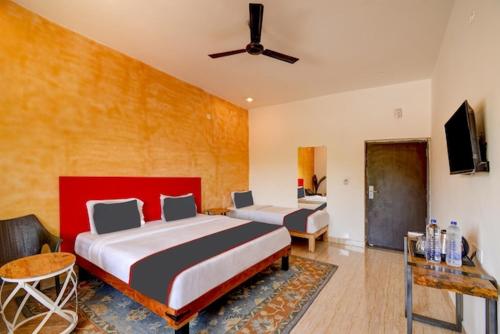 Cette chambre comprend deux lits et une télévision. dans l'établissement Royal Casa - Asra Hotel, à Chandrāvati