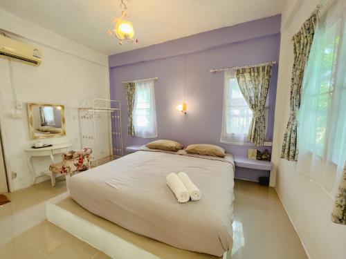 a bedroom with a large bed with two towels on it at เนริสารีสอร์ท เขาค้อ in Ban Khao Ya Nua