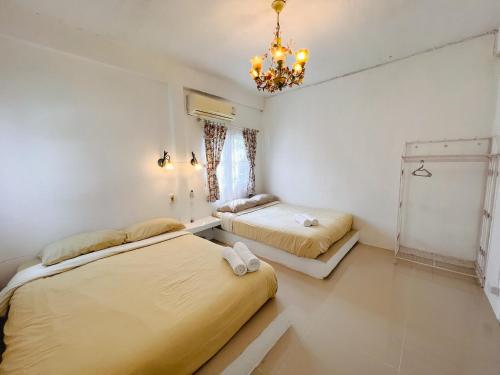 a bedroom with two beds and a chandelier at เนริสารีสอร์ท เขาค้อ in Ban Khao Ya Nua