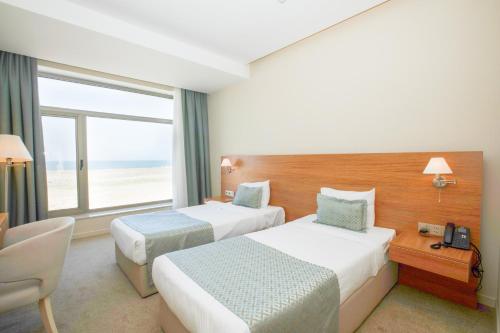 a hotel room with two beds and a window at Khazar Inji in Baku