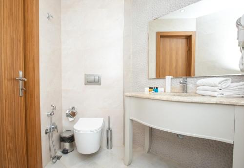 uma casa de banho com um lavatório, um WC e um espelho. em Khazar Inji em Baku