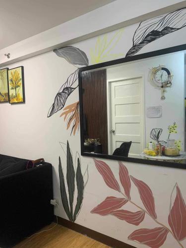 a mirror on a wall with a painting of plants at ArezzodeLaila in Davao City