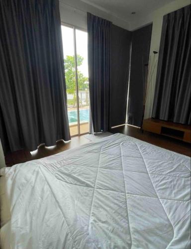 a bedroom with a large bed with a large window at Banbangei Riverside Poolvilla in Ban Bang Rathuk