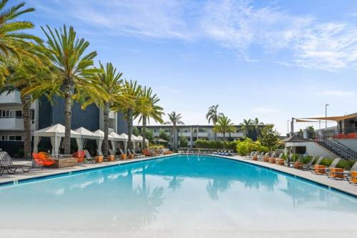 una gran piscina con palmeras y edificios en Luxurious stay near the beach, en Newport Beach