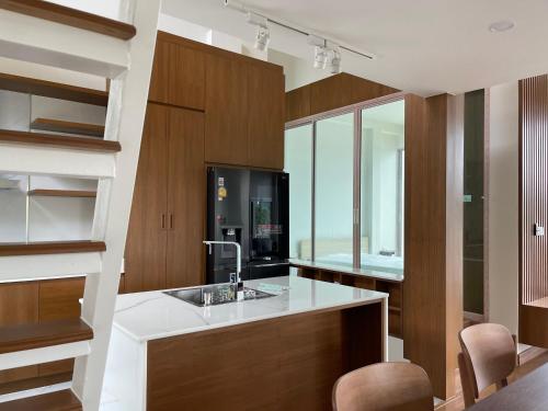 a kitchen with a sink and wooden cabinets at Banbangei Riverside Poolvilla in Ban Bang Rathuk
