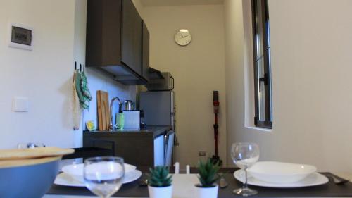 uma cozinha com uma mesa com pratos e copos de vinho em Lago Maggiore Lake Me Home apartment em Sesto Calende