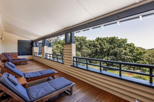 a room with a balcony with chairs and a large window at Caves House Hotel & Apartments Yallingup in Yallingup