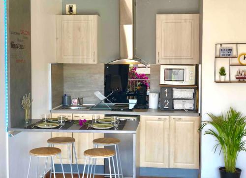 eine Küche mit einer Theke mit Hockern in der Unterkunft 2 min de la Plage, Parking, Terrasse & Wifi! in Six-Fours-les-Plages