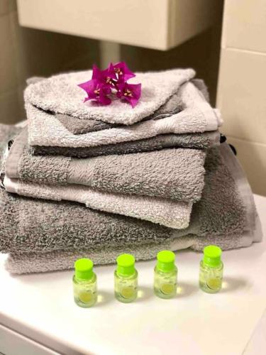 une pile de serviettes assises au-dessus d'un comptoir de salle de bains dans l'établissement 2 min de la Plage, Parking, Terrasse & Wifi!, à Six-Fours-les-Plages