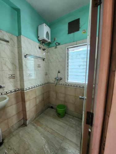 uma casa de banho com um WC, um lavatório e uma janela em Hotel Priyanka International em Āsansol