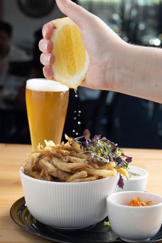 a person holding a piece of bread over a bowl of food at Adelaide Rockford in Adelaide