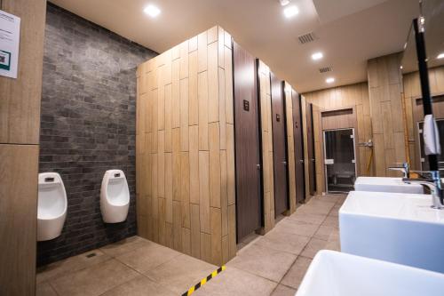 a bathroom with a row of urinals and sinks at K Avenue by Pinstay in Donggongon