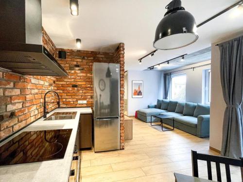 uma cozinha e sala de estar com uma parede de tijolos em Urban Apartment Deluxe Szczecin Dąbie em Szczecin