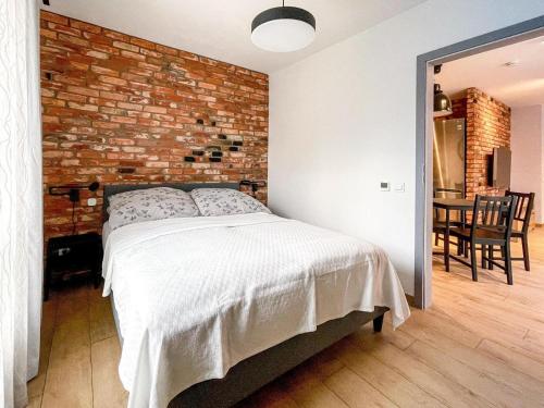 um quarto com uma parede de tijolos e uma cama em Urban Apartment Deluxe Szczecin Dąbie em Szczecin