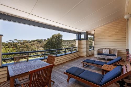 a room with a balcony with a table and chairs at Caves House Hotel & Apartments Yallingup in Yallingup