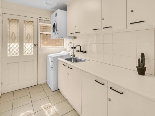 a white kitchen with a sink and a refrigerator at BIG4 Ingenia Holidays Queenscliff Beacon in Queenscliff
