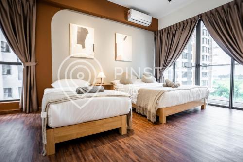 two beds in a hotel room with windows at K Avenue by Pinstay in Donggongon