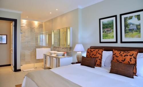 a bedroom with a large bed and a bathroom at Eden Island Luxury Accommodation in Eden Island