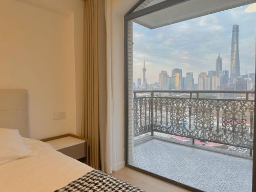 a bedroom with a window with a view of the city at Sun Garden - Near the Bund in Shanghai