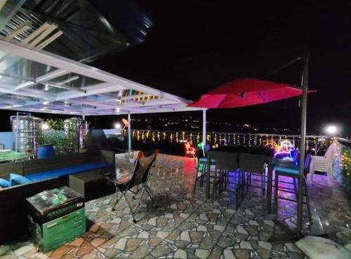 a bar with chairs and an umbrella on a patio at Mountain and Sunsetview Baguio Residences in Baguio