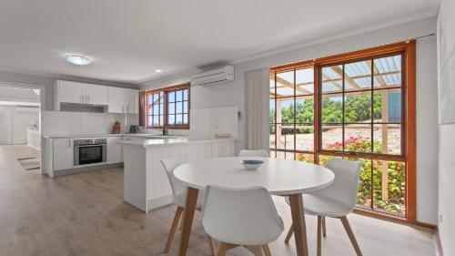 a kitchen with a white table and white chairs at Bimbadeen in Coffin Bay