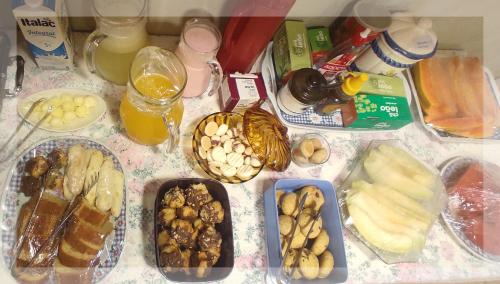 uma mesa com diferentes tipos de alimentos e bebidas em Casa D'Aurora em Campos do Jordão